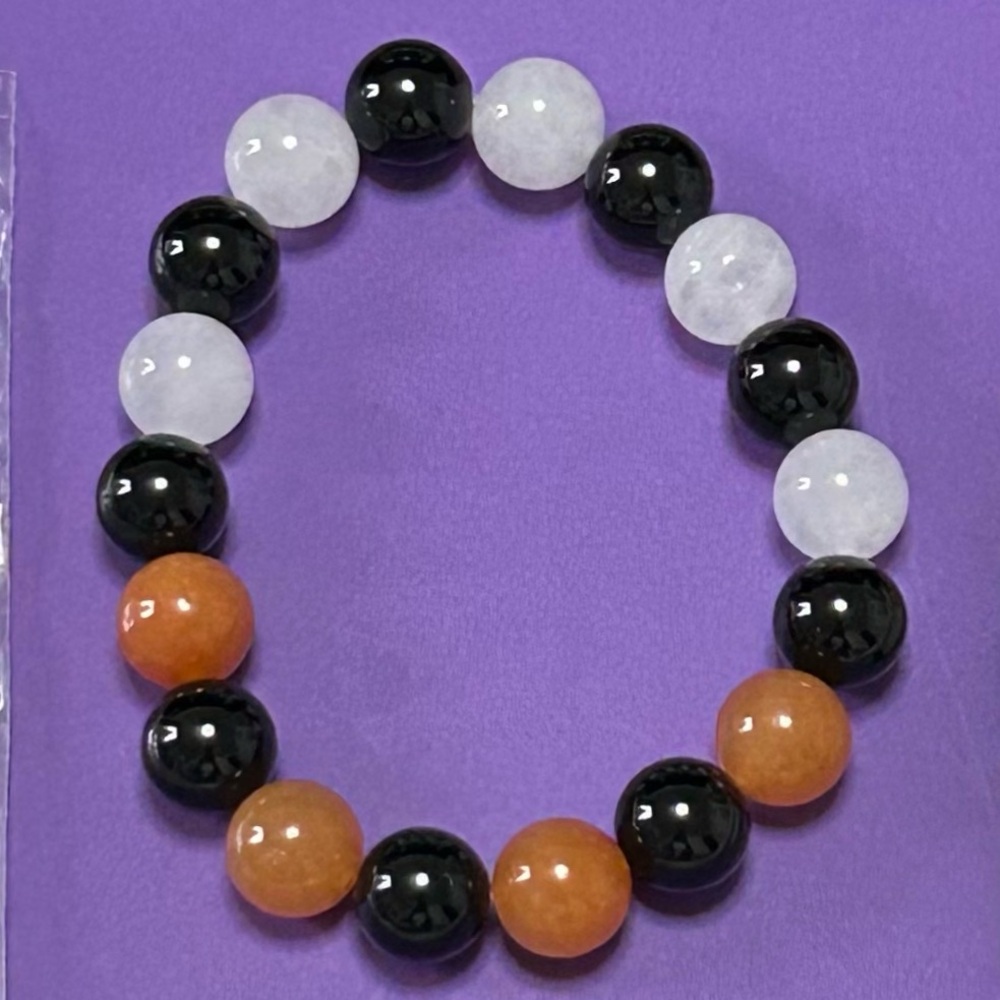homemade bracelet with black onyx, white jade, and orange calcite beads